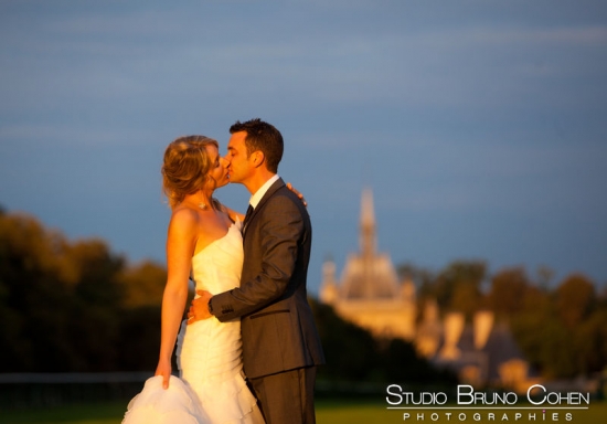 baiser des mariés devant le Chateau de Chantilly flou au fond