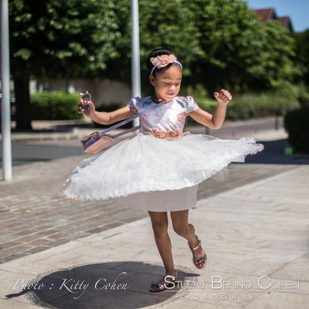 photographe mariage Gouvieux petite fille d'honneur qui danse sur la place de la Mairie