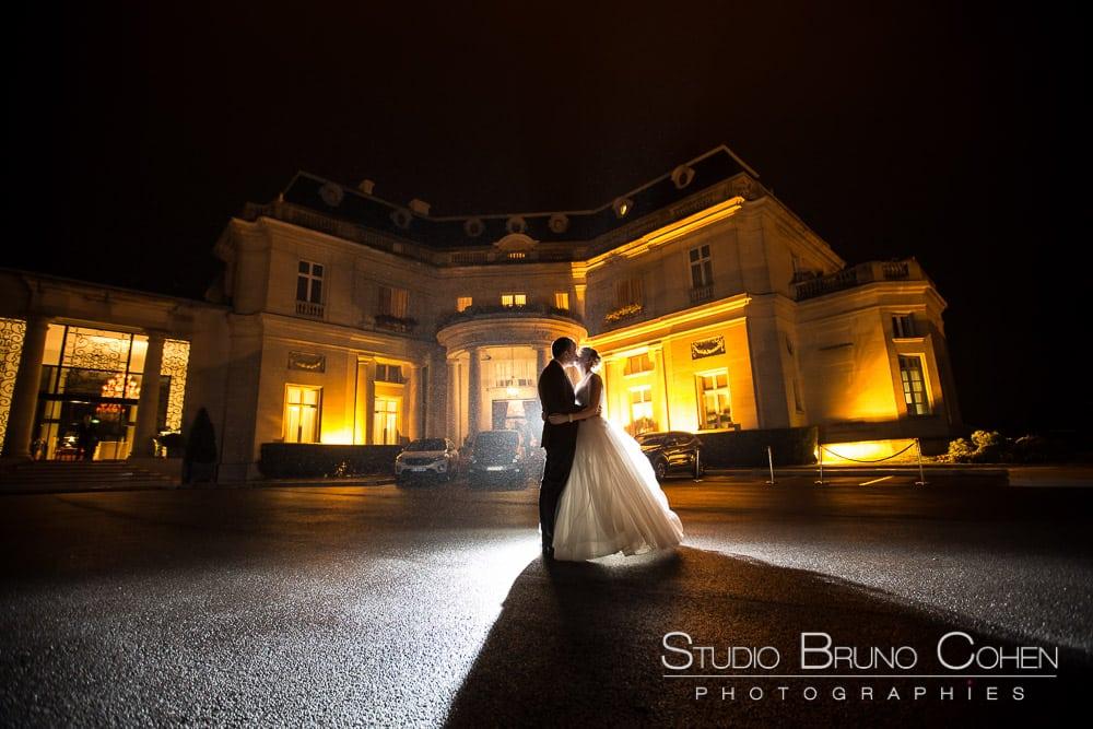 mariés de nuit en contre jour devant le chateau-hotel tiara montroyal chantilly