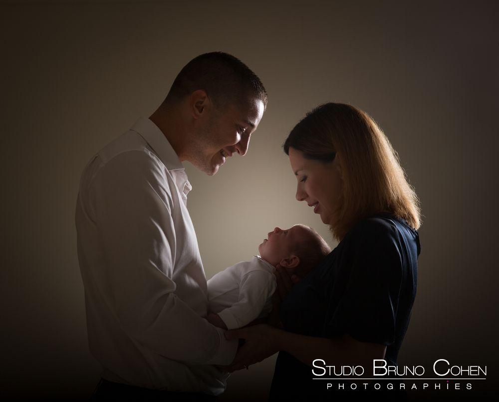 portrait d'un couple en studio tenant un bébé dans ses bras, contre-jour